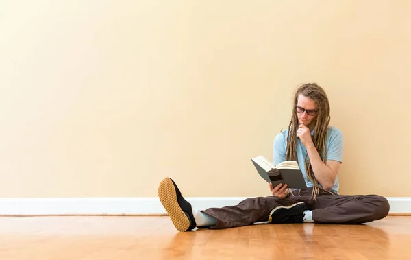 Gözlüklü genç adam kitap okuyor. — Stok fotoğraf