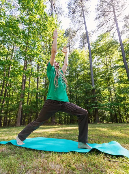 Homem em uma pose de ioga fora — Fotografia de Stock