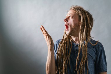 Genç adam sağlam bir arka plan üzerinde esneme