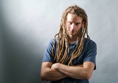 Adam katlanmış kolları olan dreadlocks ile