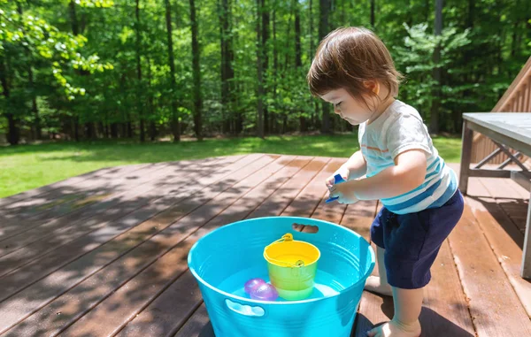 水と遊ぶ若い幼児の少年 — ストック写真