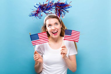 Bir Amerikan bayrağı tutan mutlu genç kadın