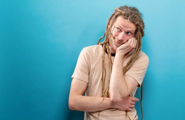 Sağlam bir arka plan üzerinde sıkılmış genç adam