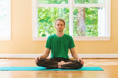 Adam bir meditasyon poz parlak bir oda içinde