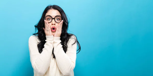 Surpreendida jovem mulher em um fundo brilhante — Fotografia de Stock