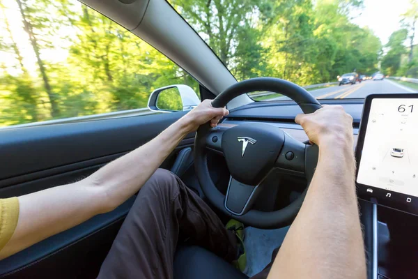 Человек за рулем новой Tesla Model 3 — стоковое фото