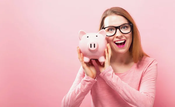 Young woman with a piggy bank — Stock Photo, Image