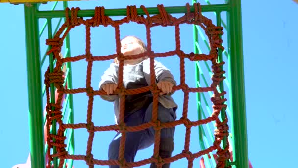 Petit garçon jouant sur le terrain de jeu 