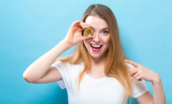 Kvinna som håller en fysisk bitcoin — Stockfoto