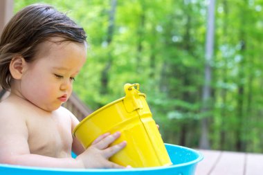 Küçük bir küvet içinde oynarken yürümeye başlayan çocuk