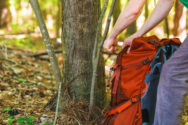 Hiker holding his camping backpack