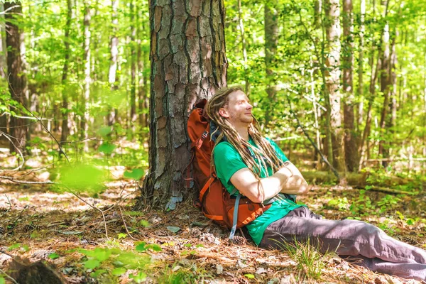 Escursionista con zaino che dorme contro un albero — Foto Stock