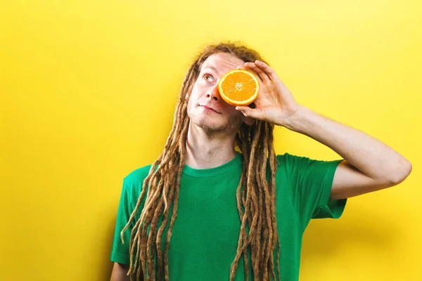 Feliz joven sosteniendo mitades naranjas — Foto de Stock