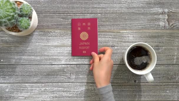 Person placing a Japanese passport on a desk — Stock Video