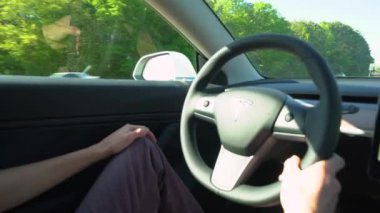 Kişi yeni bir Tesla Model 3 sürüş. Model 3 Tesla ilk kitlesel pazar elektrikli araç olarak ayarlanır.