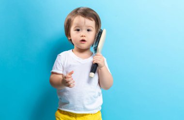 Bir saç fırçası ile yürümeye başlayan çocuk