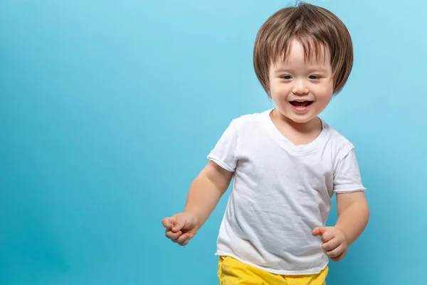 Peuter jongen lachend op een blauwe achtergrond — Stockfoto