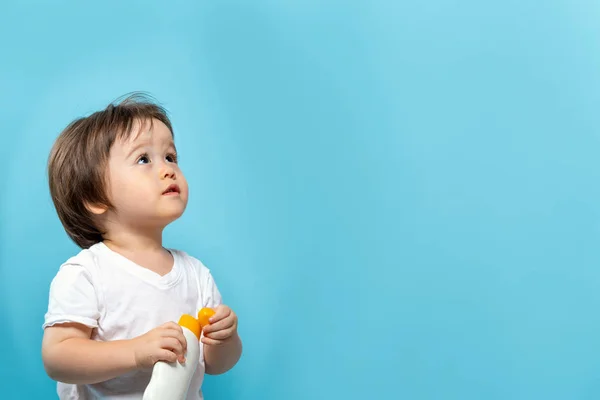 Petit garçon avec une bouteille de crème solaire — Photo