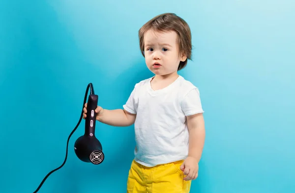 Bambino ragazzo con un asciugacapelli — Foto Stock