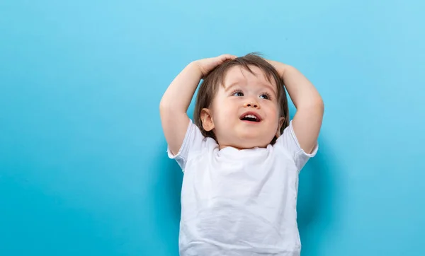 Enfant garçon souriant sur un fond bleu — Photo