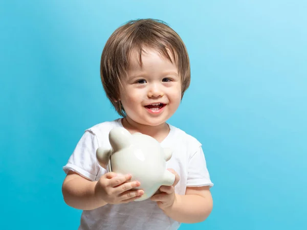 Toddler boy with a piggy bank — Stock Photo, Image