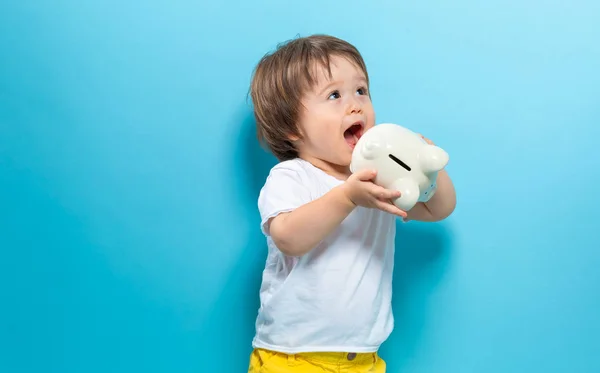 Kleuter jongen met een piggy bank — Stockfoto