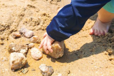 Kumda oynayan yürümeye başlayan çocuk