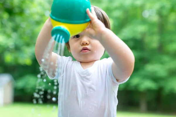 Jonge peuter jongen spelen met water — Stockfoto