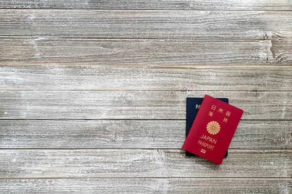 Pasaporte estadounidense y japonés en un escritorio de madera — Foto de Stock