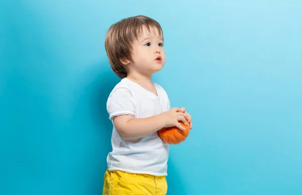 Peuter jongen houdt een pompoen voor halloween — Stockfoto