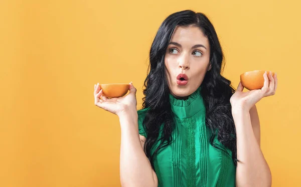 Mujer joven sosteniendo naranjas —  Fotos de Stock