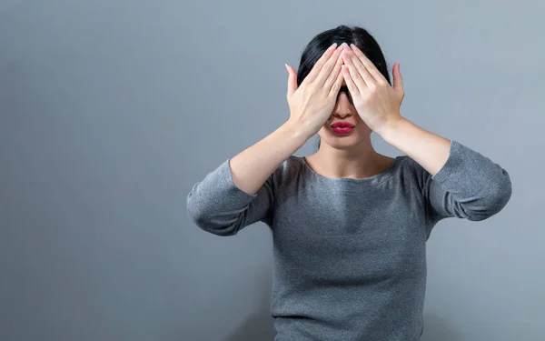 Kvinna som täcker sina ögon med händerna — Stockfoto