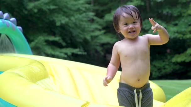Gelukkig peuter speelt in zijn achtertuin zwembad — Stockvideo