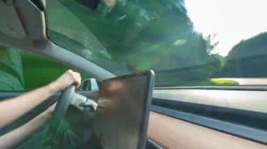 Kişi yeni bir Tesla Model 3 otomatik pilot içinde sürüş. Model 3 Tesla ilk kitlesel pazar elektrikli araç olarak ayarlanır.