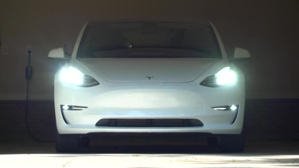 Un nuevo Tesla Modelo 3 blanco. El modelo 3 será el primer vehículo eléctrico del mercado masivo de Teslas — Vídeo de stock