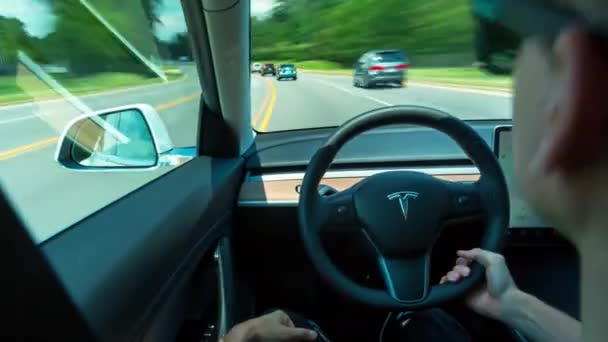 Pessoa dirigindo um novo Tesla Modelo 3 em piloto automático. O modelo 3 é definido para ser o primeiro veículo elétrico do mercado de massa Teslas — Vídeo de Stock