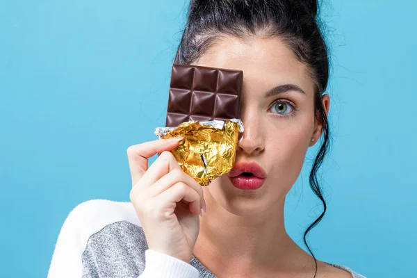Молодая женщина держит шоколад — стоковое фото
