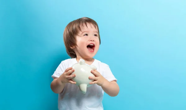 Kleuter jongen met een piggy bank — Stockfoto