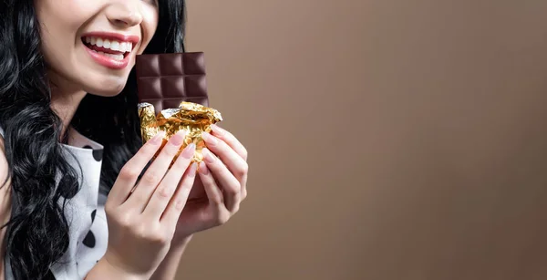 Mujer joven sosteniendo chocolate — Foto de Stock