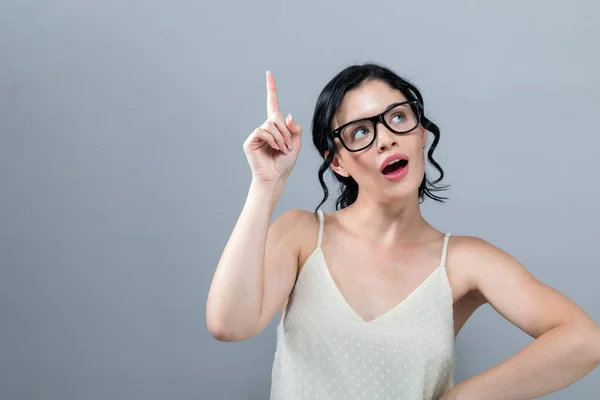 Mujer joven alcanzando y mirando hacia arriba — Foto de Stock