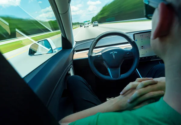 Persona que usa la función de auto-conducción en un Tesla Modelo 3 eléctrico — Foto de Stock