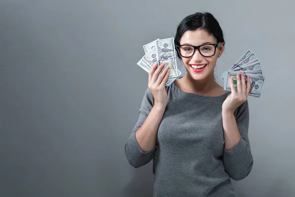 Mujer joven con una pila de dinero en efectivo USD — Foto de Stock