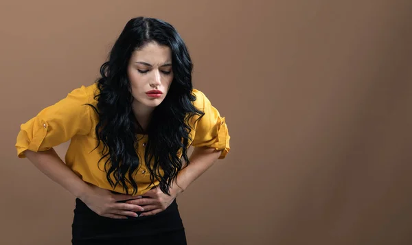 Mujer joven sufriendo de dolor de estómago —  Fotos de Stock