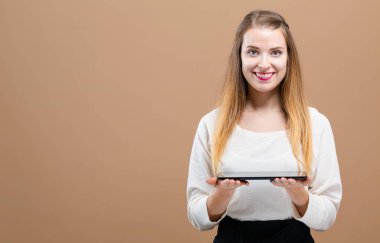 Tablet bilgisayarı olan genç bir kadın