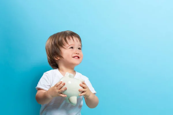 Toddler boy with a piggy bank — Stock Photo, Image