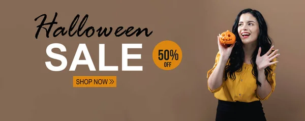 Хэллоуинская распродажа с женщиной, держащей тыкву — стоковое фото