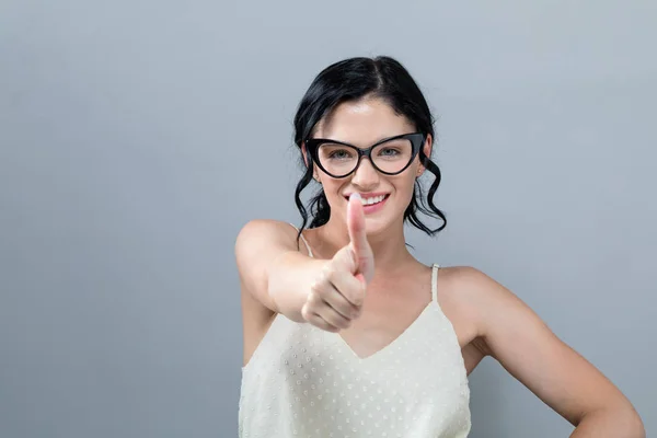 Joven mujer dando pulgar hacia arriba — Foto de Stock