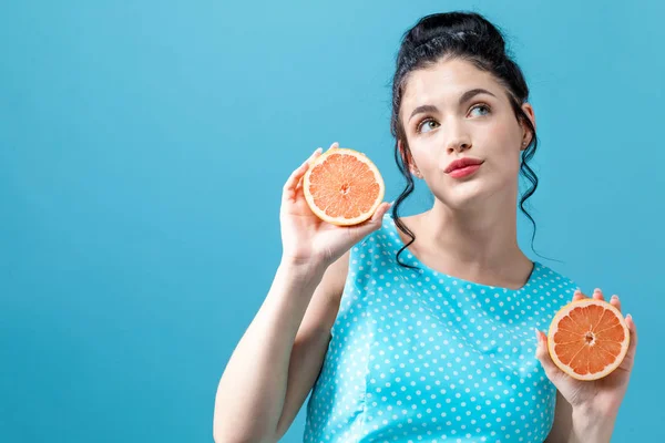 Счастливая молодая женщина с апельсинами — стоковое фото