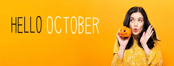 Olá Outubro com a mulher segurando uma abóbora — Fotografia de Stock