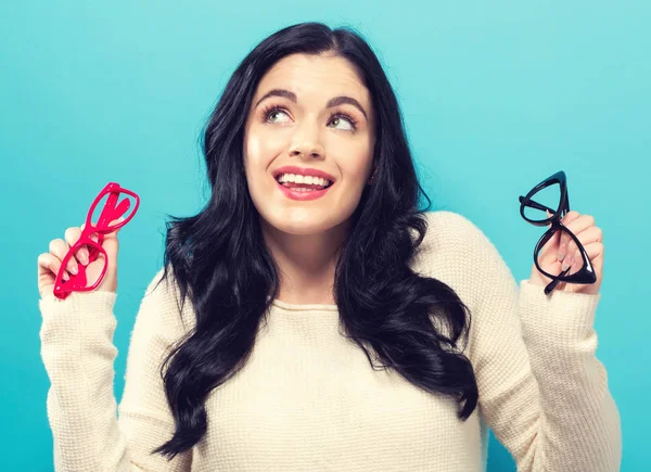 Mujer joven comparando dos anteojos —  Fotos de Stock